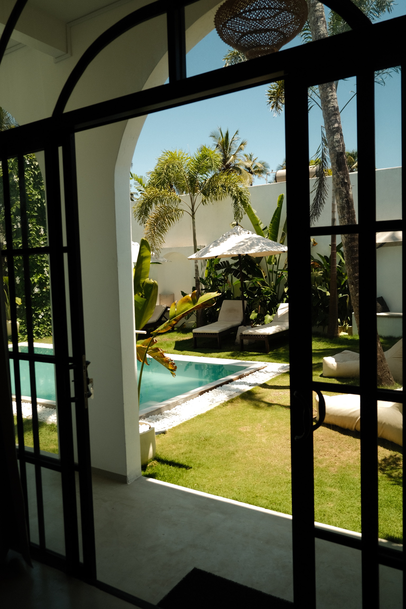 Garden and pool view through the villa's arched doors